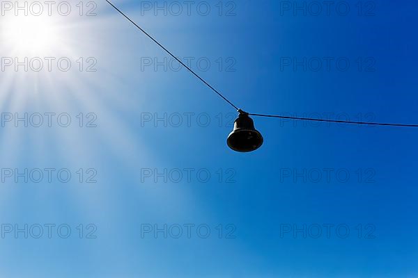 Single discarded bell hanging on steel cable, sound body