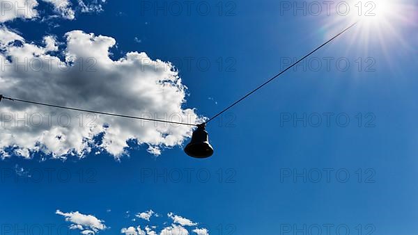 Single discarded bell hanging on steel cable, sound body