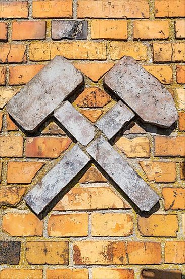 Mining symbol hammer and iron, avenue of construction machinery from opencast lignite mining