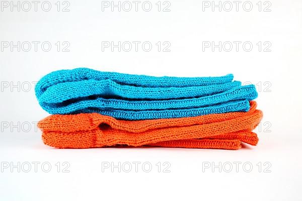 Self-knitted socks made of wool isolated against a white background in orange and blue,