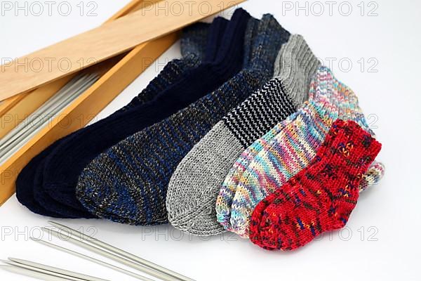 Self-knitted socks made of wool isolated against a white background. In different colours and sizes,