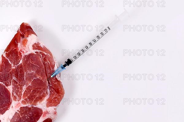 Concept for genetically modified animals or antibiotics and medicine residue in food with raw red meat with injected syringe,