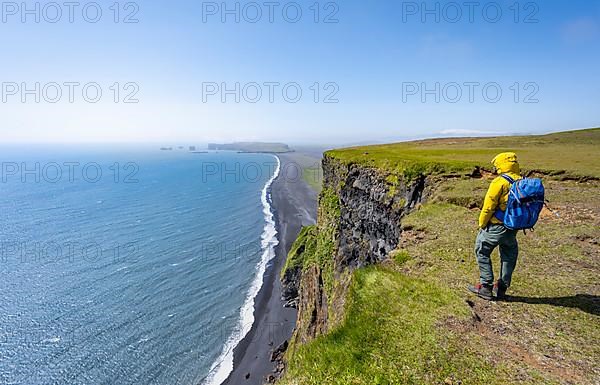 Hikers on cliff, View over Reynisfjara beach