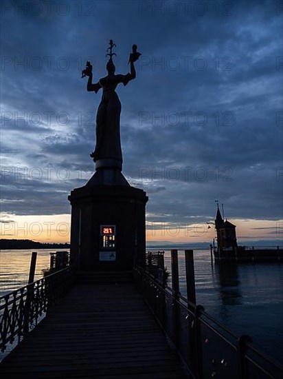 Statue of Imperia at the harbour entrance of Constance in the morning light in front of sunrise, Old Town