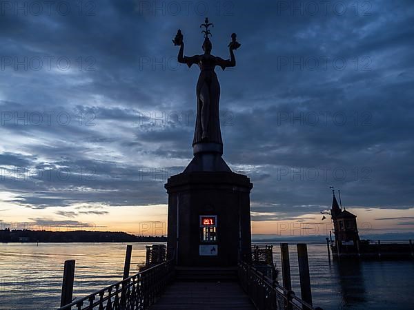 Statue of Imperia at the harbour entrance of Constance in the morning light in front of sunrise, Old Town