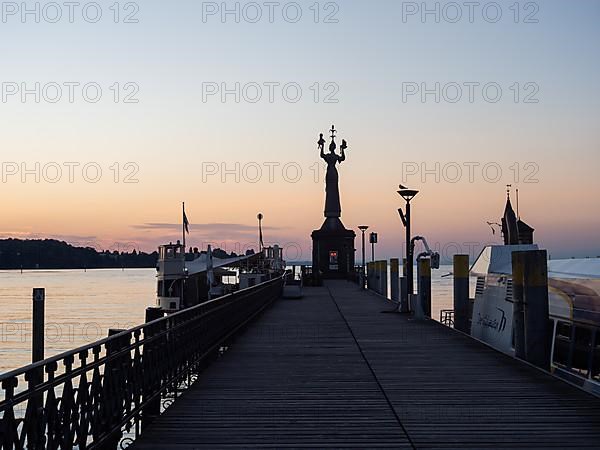 Statue of Imperia at the harbour entrance of Constance in the morning light in front of sunrise, Old Town