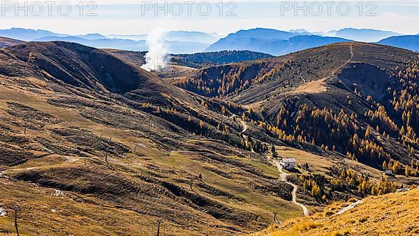 Rising smoke in autumnal landscape, skiing and hiking area Merano 2000