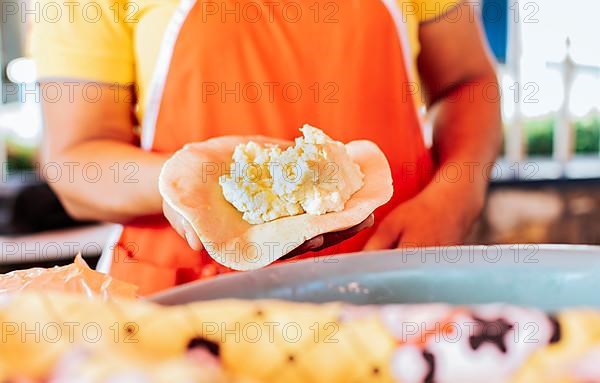 Hands of a vendor showing traditional raw pupusa. Elaboration of traditional pupusas, elaboration of the dough for traditional Nicaraguan pupusas