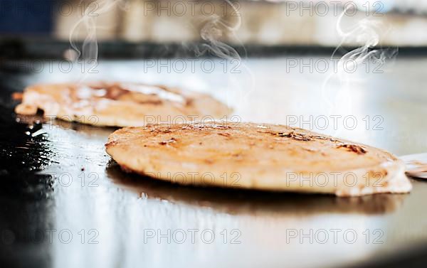 Close up of traditional handmade pupusas on grill, Traditional Nicaraguan Pupusas with melted cheese on grill. Traditional grilled cheese pupusas