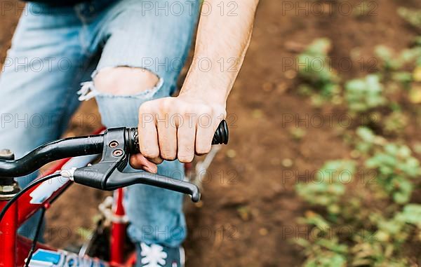 Side view of hands on bicycle handlebars with copy space. Concept of cyclist hands on the handlebars, Close up of hands on bicycle handlebars