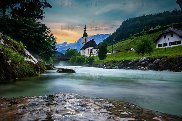 Parish church of St. Sebastian, with wooden bridge over a stream