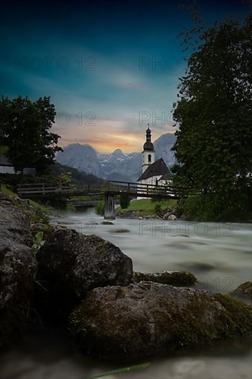 Parish church of St. Sebastian, with wooden bridge over a stream