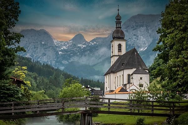 Parish church of St. Sebastian, with wooden bridge over a stream