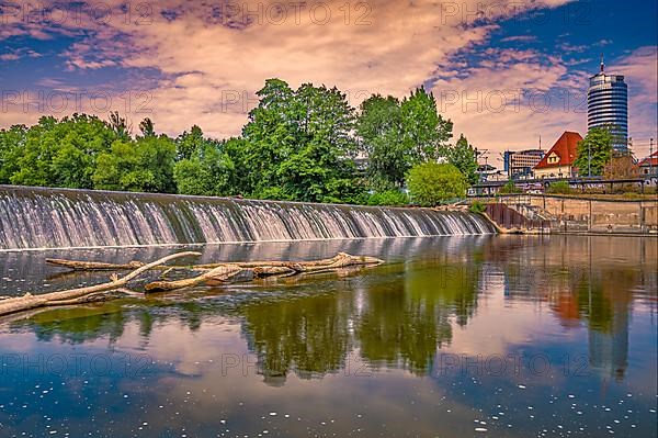 The weir of the river Saale in Paradies Park with the Jentower in the background at sunrise, Jena