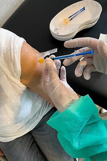 Elderly woman receives injection with medical syringe fourth vaccination booster vaccination against coronavirus disease Covid-19 C19 corona virus Corona virus, Germany