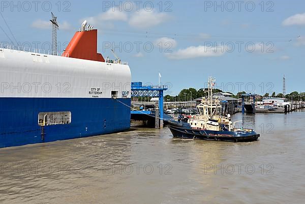 Tugboats move a special ship loaded with cars in the outer harbour, Emden