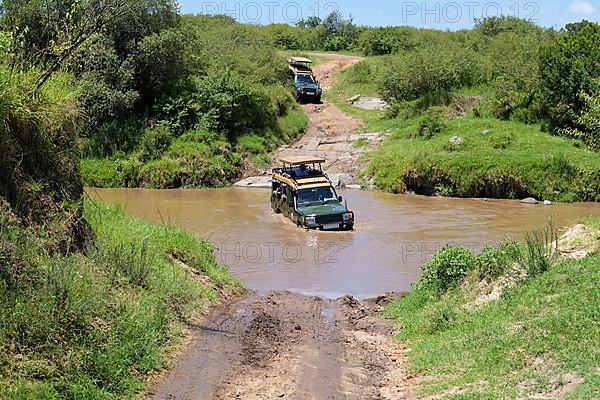 Safari jeep driving through river, Masai Mara National Reserve