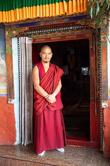 Monk at the entrance to the prayer hall, Diskit Monastery or Deskit Gompa