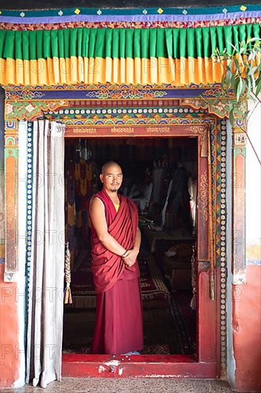 Monk at the entrance to the prayer hall, Diskit Monastery or Deskit Gompa