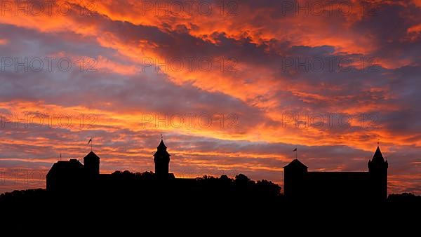 Fiery red evening sky after sunset with skyline, silhouette from left Kaiserburg with Heidenturm and Sinwellturm