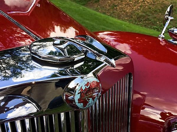 Radiator mascot and classic logo with world map and lettering Triumph of historic classic sports car Triumph 1800 Roadster, Classic Days