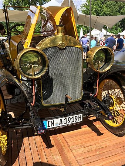 Front view front with radiator grill round lamps spoke wheel of historic racing car from early 20th century 1919 Audi Phaeton Type C Alpine winner, Classic Days