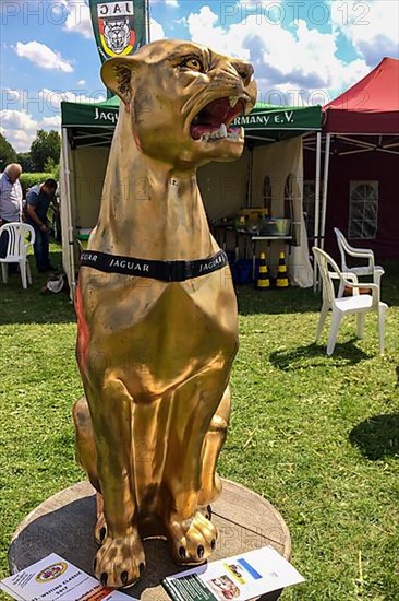 Shimmering gold statue of Jagauar in front of exhibition pavilion of Jaguar Club Germany, Classic Days