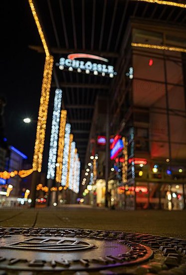 Christmas lights in the city centre of Pforzheim, manhole cover lid with emblem of the city of Pforzheim in the foreground