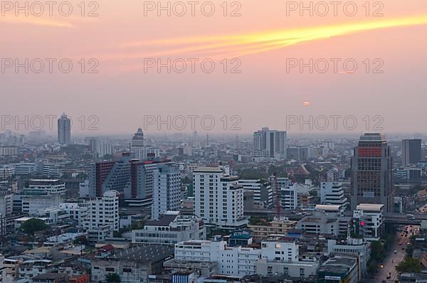 Sunset over downtown Bangkok with haze for agricultural burning, from rooftop restaurant of the Siam@Siam Hotel
