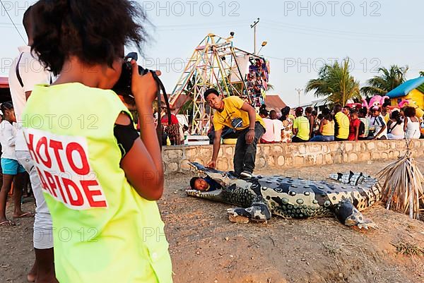 Photographer, photographs man and child with artificial crocodile