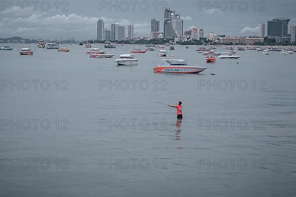 Thai man fishing, Central Pattaya Beach
