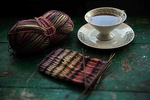 Handmade, Knitted piece with knitting needles and coffee