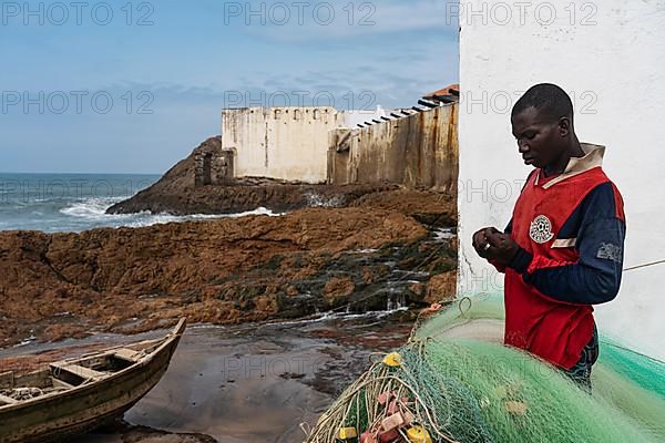 Fisherman mending net, fishing boat