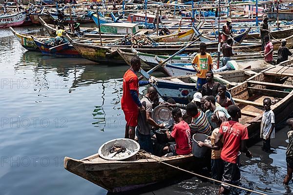 Fisherman with catch in fishing boat, fish market