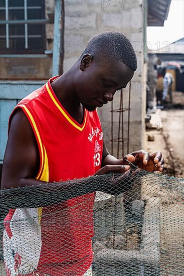 Fisherman mending nets, Elmina