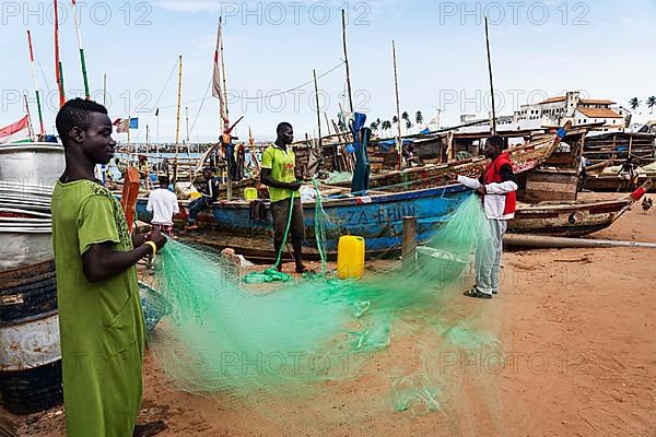 Fishermen mending nets, fishing boats
