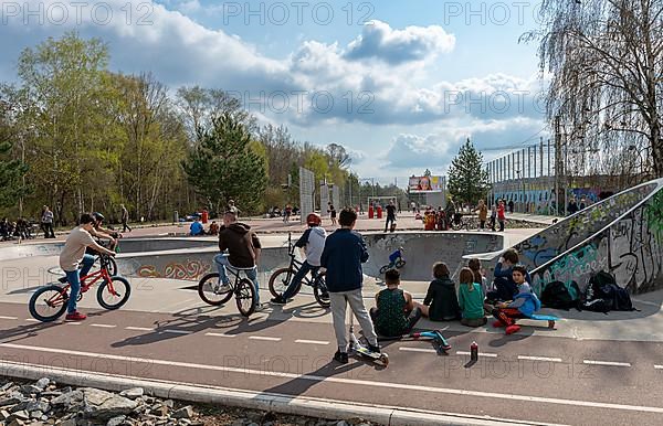 Skateboarders and cyclists at a skate pool in the Park am Gleisdreieck in Berlin-Mitte, Berlin