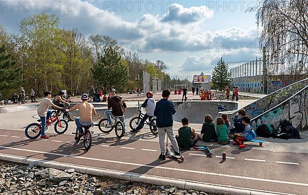 Skateboarders and cyclists at a skate pool in the Park am Gleisdreieck in Berlin-Mitte, Berlin