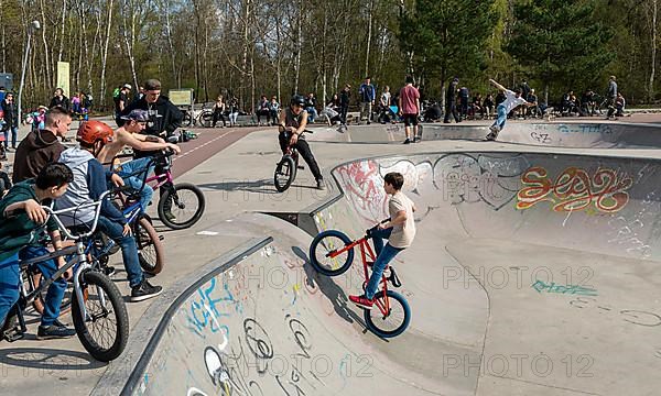 Skateboarders and cyclists at a skate pool in the Park am Gleisdreieck in Berlin-Mitte, Berlin