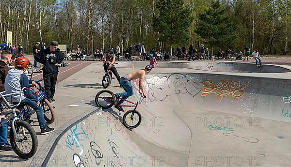 Skateboarders and cyclists at a skate pool in the Park am Gleisdreieck in Berlin-Mitte, Berlin