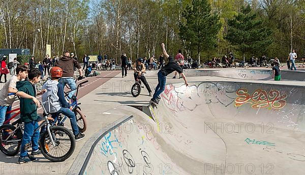 Skateboarders and cyclists at a skate pool in the Park am Gleisdreieck in Berlin-Mitte, Berlin