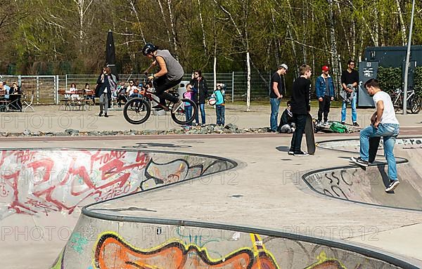 Skateboarders and cyclists at a skate pool in the Park am Gleisdreieck in Berlin-Mitte, Berlin