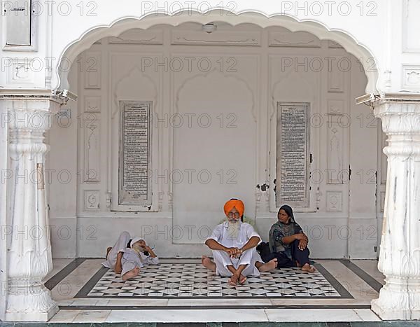 Indian Sikhs in white suits and bare feet at the Hari Mandir or Golden Temple, Amritsar