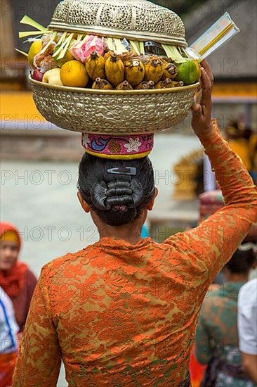 Balinese woman carrying an offering basket inside Pura Tirta Empul, Bali