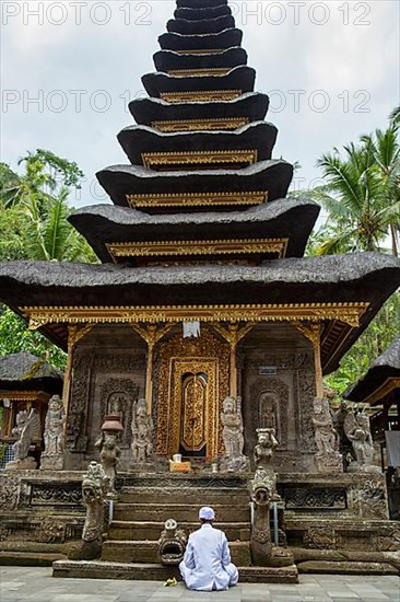 Hindu priest praying inside Pura Kehen, Kintamani