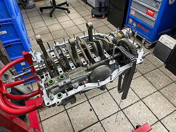 Gearbox for air-cooled engine of historic classic sports car classic car Porsche 911 964 overhauled restored in workshop on rack for assembly assembly rack, Germany