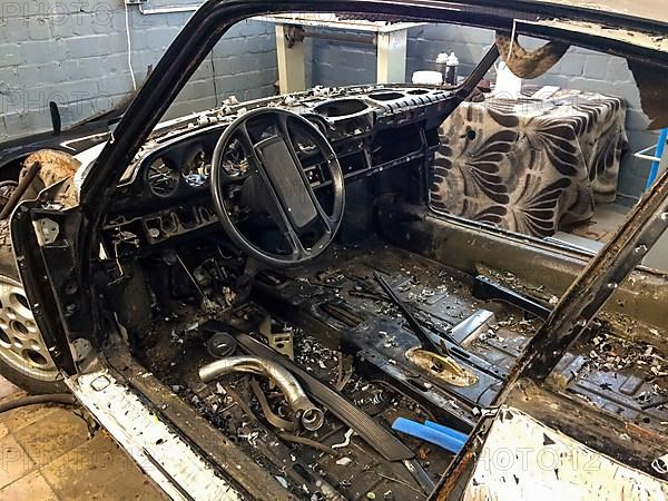 Gutted rusty body of historic classic sports car Classic Car Porsche 911 G model is prepared for restoration Reconstruction, Germany