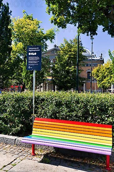 Bench in rainbow colours with welcome sign of the Oxlo initiative, Oslo Extra Large for diversity and integration