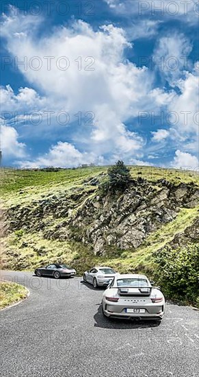 Three Porsche sports cars in front 911 GT3 behind Cayman 718 in the background 911 997 driving through a bend at Passo della Teglia, Ligurian Alps