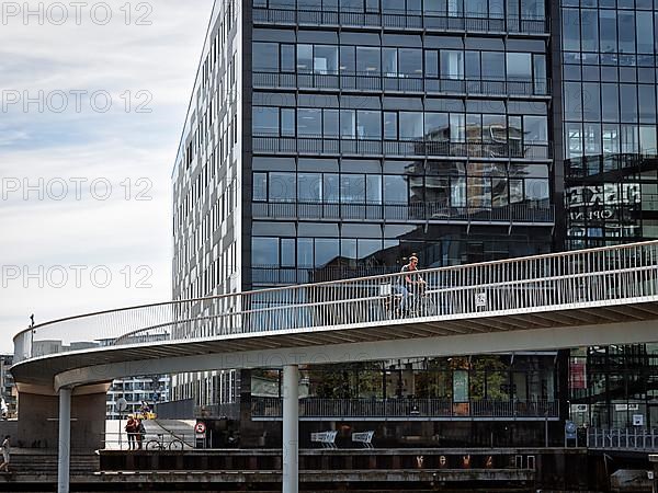 Cyclists on bridge over inner harbour basin, Cykelslangen bicycle bridge